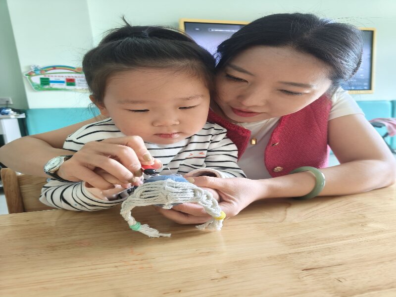 图片二：教师指导幼儿扎染的方法.jpeg