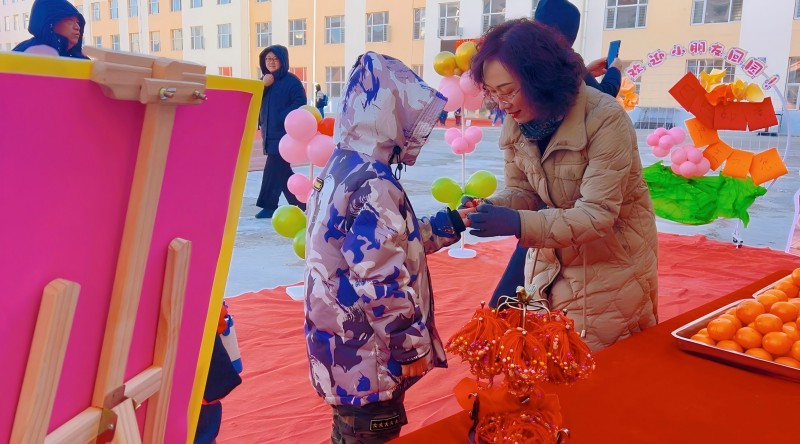 2园长为幼儿系红绳.jpg