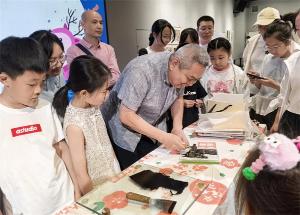 图片二 版画家郑子江为小朋友们示范油印版画技法.jpg